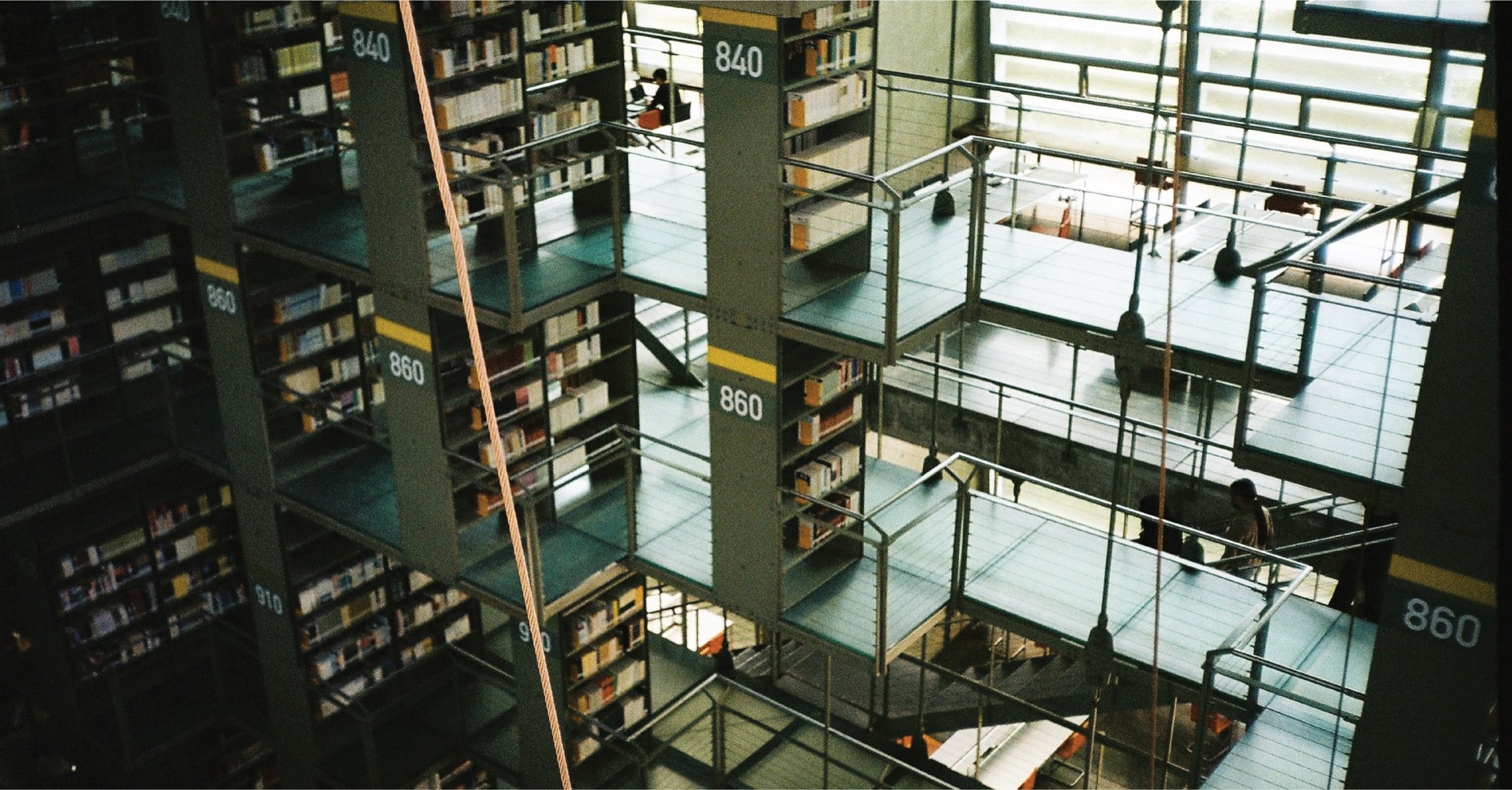 Fotografía de una gran biblioteca con estanterías numeradas y pasarelas
