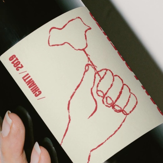 Detalle de la ilustración de la etiqueta: una mano que sostiene una rosa, con «Chianti / 2019» en vertical